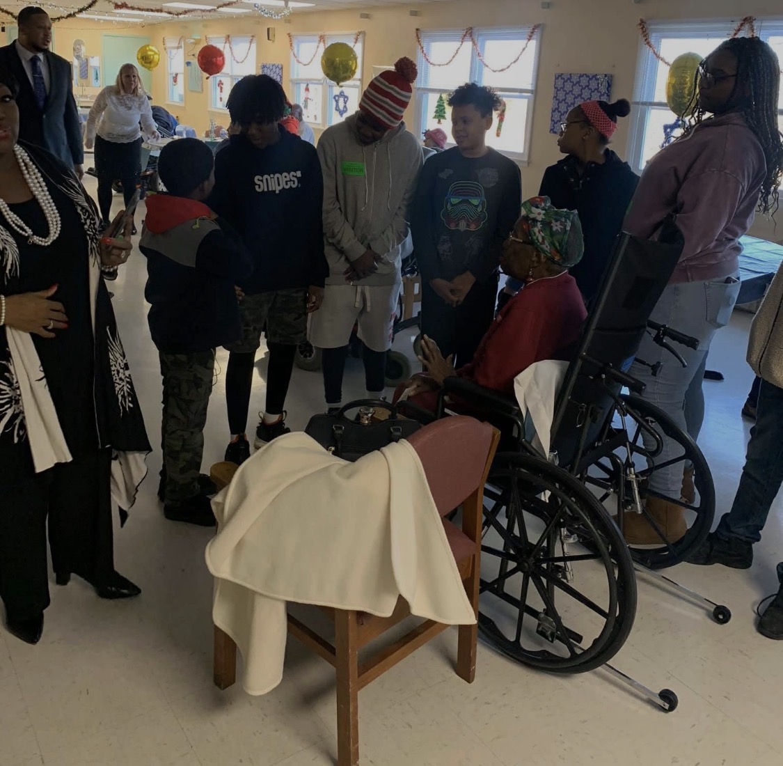 Youth praying with a senior mother during a community visit